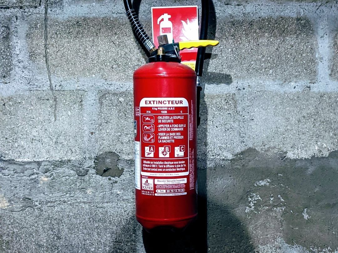 Rødt brannslokkningsapparat på murvegg